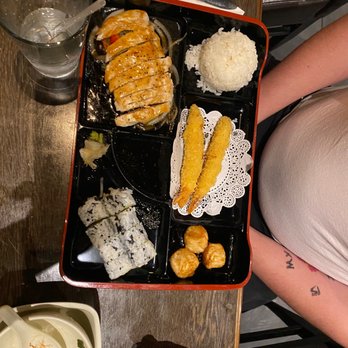 Shogun - a person sitting at a table with a tray of food - Sushi Bars Near Me - Bismarck, North Dakota Shogun - a person sitting at a table with a tray of food - Sushi Bars Near Me - Bismarck, North Dakota