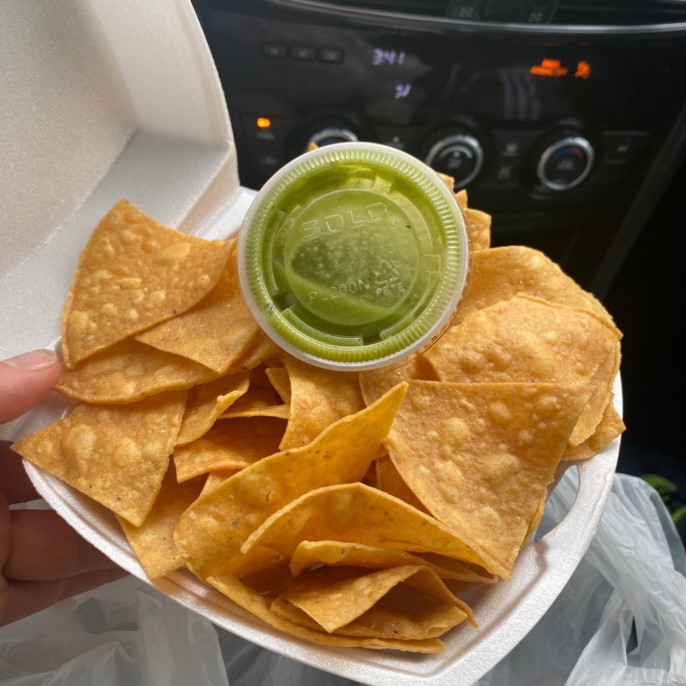 a person holding a container of chips a person holding a container of chips