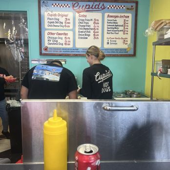 Cupid’s Hot Dogs - We were sitting at the counter you can see the menu and them working - Hot Dogs Near Me - Longwood, Florida