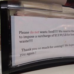 Lataohotpot - Warning on napkin dispenser about cost to waste food