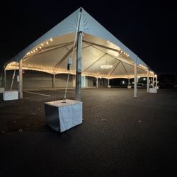 Lake Norman Party Rentals - 30X60 Future Trac Tent with market lights around perimeter and a chandelier in the center.