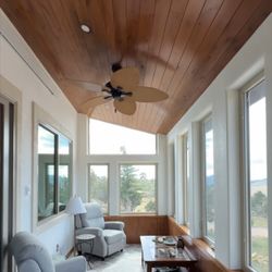 Stonebrook Construction Group - Custom sunroom featuring vaulted wood ceiling and herringbone tile floor.