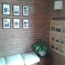 Pirola - A la entrada, pequeña salita de espera con sillones e imágenes de la construcción de un dique y caminos de Córdoba (1930/1950aprox).