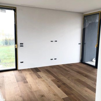 Reyes Custom Floor - a room with wood floors and a sliding glass door - Flooring Near Me