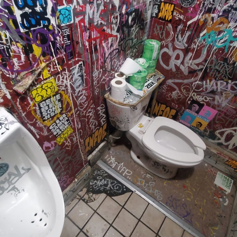Iggy's Keltic Lounge - a bathroom with graffiti on the walls - Dive Bars Near Me - New York, New York