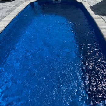 Kline Brothers - a blue pool with chairs and umbrellas - General Contractors Near Me - Manahawkin, New Jersey