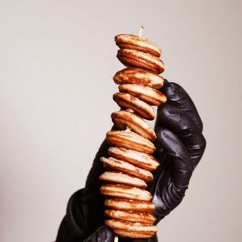 Batterhouse - a hand holding a stack of cookies - Desserts Near Me Batterhouse - a hand holding a stack of cookies - Desserts Near Me