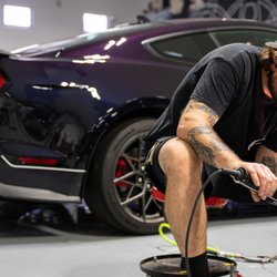 Colton seen here polishing a classic fastback Ford Mustang, with a new Mach 1 waiting patiently!