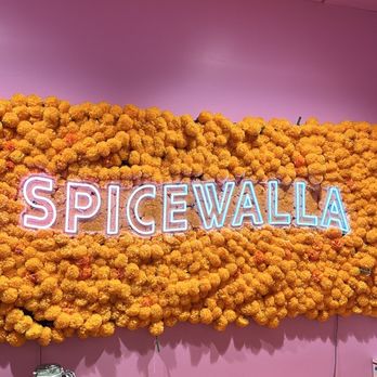 Spicewalla - a neon sign in front of a wall of flowers - Herbs & Spices Near Me - Atlanta, Georgia Spicewalla - a neon sign in front of a wall of flowers - Herbs & Spices Near Me - Atlanta, Georgia