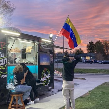 Tu Vianda Food Truck - a man holding a flag - Food Trucks Near Me Tu Vianda Food Truck - a man holding a flag - Food Trucks Near Me