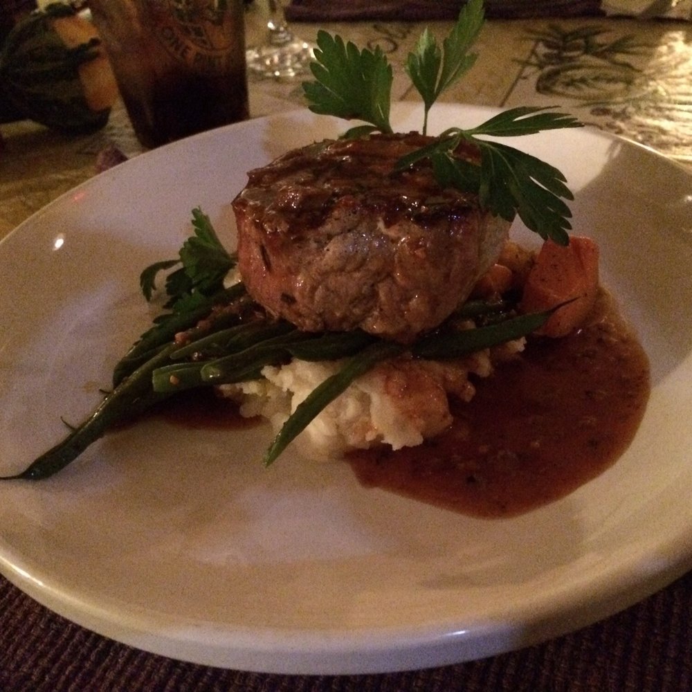 The double cut pork chop cooked to perfection and served with fresh green beans, yams, and mashed potatoes.
