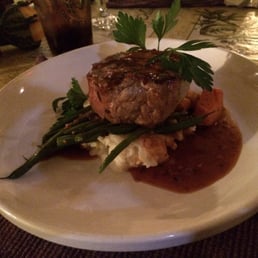 The double cut pork chop cooked to perfection and served with fresh green beans, yams, and mashed potatoes.