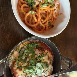 Chicken Parmesan with a side of bucatini with tomato sauce Chicken Parmesan with a side of bucatini with tomato sauce