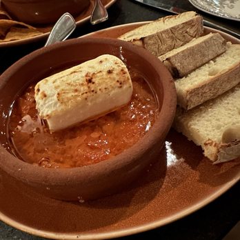 Aguardente - Baked goat cheese in tomato, garlic, paprika sauce, w/ Portuguese corn bread - Cocktail Bars Near Me - Providence, Rhode Island