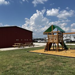 Holiday Road RV Park - Enjoy family time outdoors with swings, a covered play tower, and nearby picnic tables at Holiday Road RV Park.
