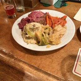 Corn beef, mashed potatoes, carrots, and cabbage served with soda bread and applesauce.