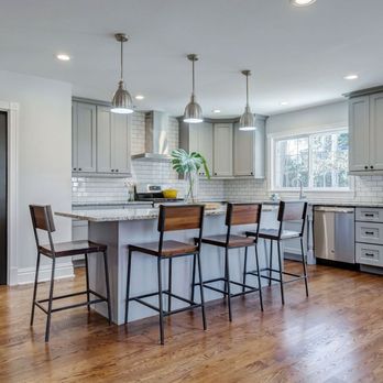 Butterfly Kitchens - a kitchen with a center island and bar stools - General Contractors Near Me - Delray Beach, Florida