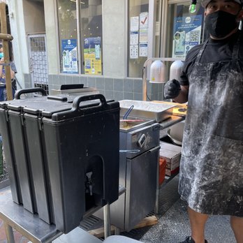 PI Wings - a man wearing a face mask cooking food - Chicken Wings Near Me