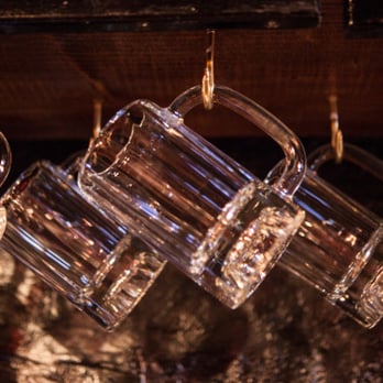 Slippery Slope - a row of glasses hanging from a bar - Dive Bars Near Me - Chicago, Illinois Slippery Slope - a row of glasses hanging from a bar - Dive Bars Near Me - Chicago, Illinois