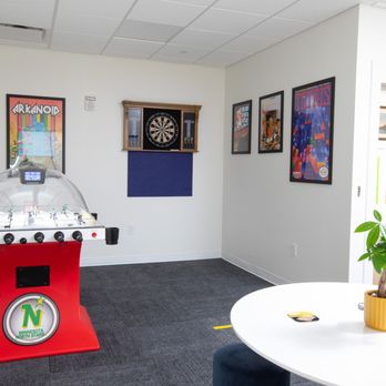 Lighthouse Technology Services - Game room with bubble hockey, darts, and retro game posters - Employment Agencies Near Me - Buffalo, New York
