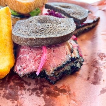 JNL Barbecue - Pastrami Sandwich (half pound sandwich served on dark pumpernickel with housemade 512 Pecan Porter mustard and pickled red onions) - Barbeque Near Me - Austin, Texas JNL Barbecue - Pastrami Sandwich (half pound sandwich served on dark pumpernickel with housemade 512 Pecan Porter mustard and pickled red onions) - Barbeque Near Me - Austin, Texas