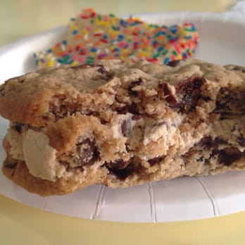 Sweet Mandy B's - The "Just Dough It" cookie, a chocolate chip cookie sandwich with cookie dough icing. Confetti cookie in the background. - Bakeries Near Me - Chicago, Illinois Sweet Mandy B's - The "Just Dough It" cookie, a chocolate chip cookie sandwich with cookie dough icing. Confetti cookie in the background. - Bakeries Near Me - Chicago, Illinois