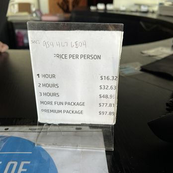 PlugIN Karaoke - A menu listing prices per person for different durations and packages, placed on a table in an indoor setting. - Karaoke Near Me - Hallandale Beach, Florida