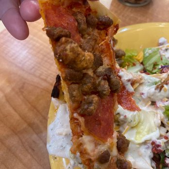 Mazzio's Italian Eatery - a hand holding a piece of pizza - Pizza Near Me - Wichita Falls, Texas Mazzio's Italian Eatery - a hand holding a piece of pizza - Pizza Near Me - Wichita Falls, Texas