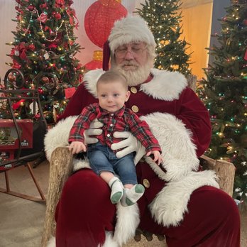 Grasshopper Gardens - santa sitting in a chair with a baby - Gardeners Near Me - Brighton, Michigan