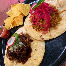 two tacos on a black plate