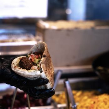 Holy Grill - a person holding a pita sandwich - Kosher Near Me - Los Angeles, California Holy Grill - a person holding a pita sandwich - Kosher Near Me - Los Angeles, California