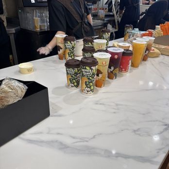 Auntea Jenny - Line of drinks sitting on the counter with no one calling out the orders.  The room is full of people waiting and it's chaotic - Bubble Tea Near Me - Irvine, California
