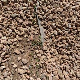 a piece of metal in the middle of a pile of rocks