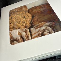 A bakery box of yummies, including chocolate chip cookies, cinnamon rolls, and more!
