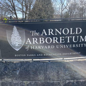 Arnold Arboretum - A black and white sign displays 'The Arnold Arboretum of Harvard University' with the Boston Parks and Recreation Department, set against a background of trees. - Parks Near Me - Boston, Massachusetts