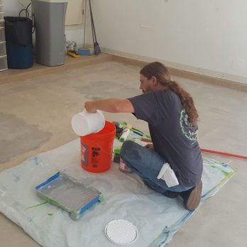 Concrete By Design - a woman sitting on the floor with a bucket of paint - Flooring Near Me - Austin, Texas Concrete By Design - a woman sitting on the floor with a bucket of paint - Flooring Near Me - Austin, Texas