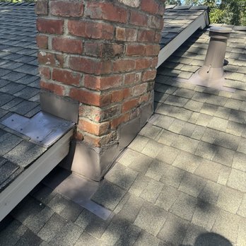 Bay City Roofing - New / painted flashing and seal around chimney.  Note use of screws instead of nails. - Roofing Near Me