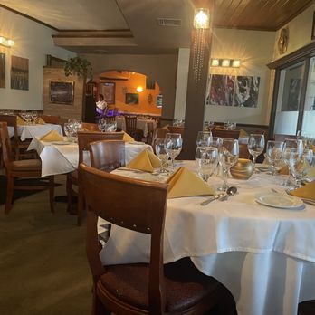 Chez Frenchie’s - a dining room with tables and chairs - Steakhouses Near Me - Vero Beach, Florida
