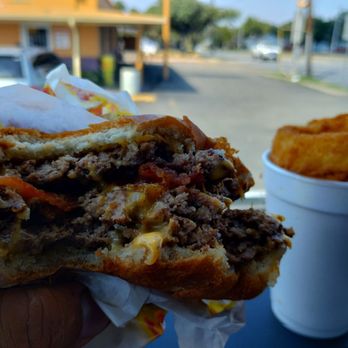 Country Burger - a hand holding a half eaten sandwich - American Near Me - Dallas, Texas Country Burger - a hand holding a half eaten sandwich - American Near Me - Dallas, Texas
