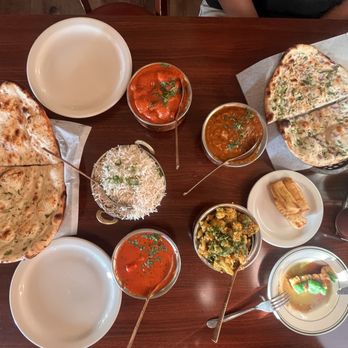 Tandoor India - Complete table left to right; Garlic Naan, Basmati Boiled Rice, Mushroom Masala, Chicken Curry. Paneer Makhani, Aloo Gobi Paneer Pakora - Indian Near Me - Santa Monica, California