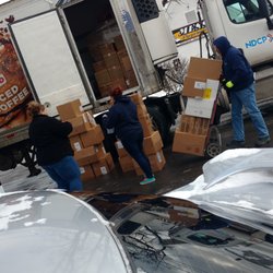 Dunkin' - This is two cigarette smoking employees at the 50 Clinton Street Dunkin Donuts, unloading food boxes onto the wet muddy dirty ground. Yuck!