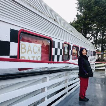Rock & Roll Diner - a woman standing in front of a train - Diners Near Me - Oceano, California Rock & Roll Diner - a woman standing in front of a train - Diners Near Me - Oceano, California