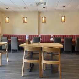 Brightly lit, clean interior seating, comfortable tables and some cushioned bank seating.