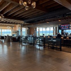 Glacier Park International Airport - FCA - Area when you come up escalator, fireplace seating area, bar, and nice store.