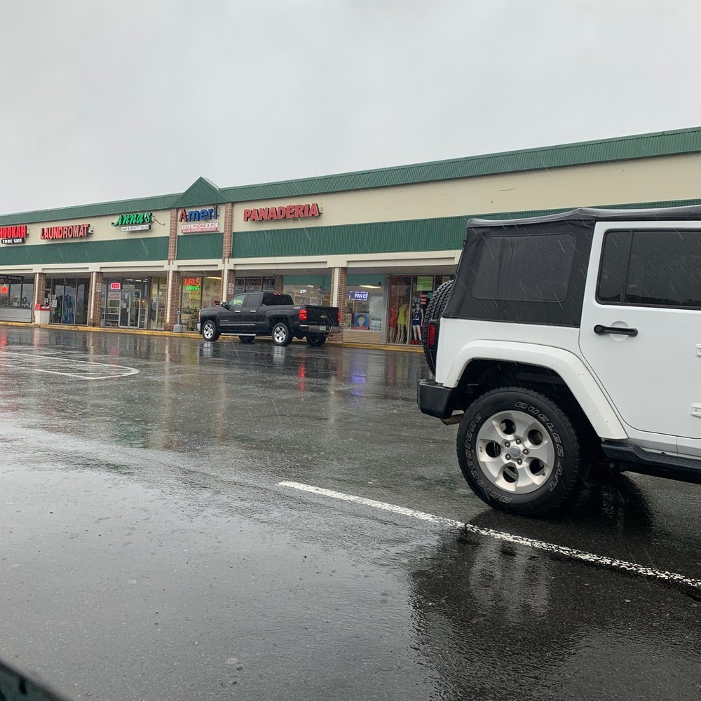 a white jeep parked in front of a store a white jeep parked in front of a store