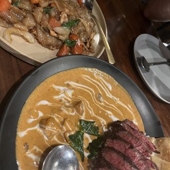 Hanuman Thai Eatery - Drunken Noodle (top), Massaman Curry with Hangar Steak (bottom) - Thai Near Me - Costa Mesa, California Hanuman Thai Eatery - Drunken Noodle (top), Massaman Curry with Hangar Steak (bottom) - Thai Near Me - Costa Mesa, California