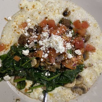 Thumbs Up Diner - Cheesy grits, spinach, tomato, vegan sausage topped with goat cheese - American Near Me - East Point, Georgia