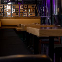 Broke Brewing Company - Casual bench seating with tables and chairs and the brewery tanks in view