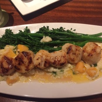 Seasons 52 - Caramelized grilled sea scallops served with butternut squash and leek risotto, broccolini & lemon butter. - New American Near Me - Sarasota, Florida