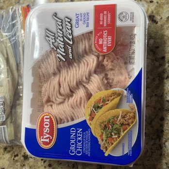 ALDI - $3 - A rectangular plastic container of Tyson ground chicken is placed on a speckled granite kitchen countertop. The label indicates it is ground chicken for tacos and other recipes, with branding and product information visible. The container has a clear lid, allowing the ground chicken inside to be seen. In the background, there are other kitchen items, including a white mug and a pink tray. - Grocery Near Me - Slidell, Louisiana